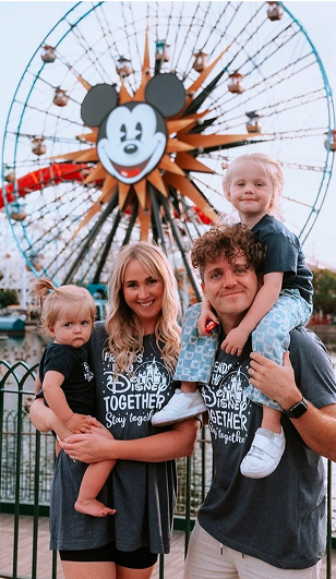 A family poses in front of Pixar Pal-A-Round at Disney California Adventure Park